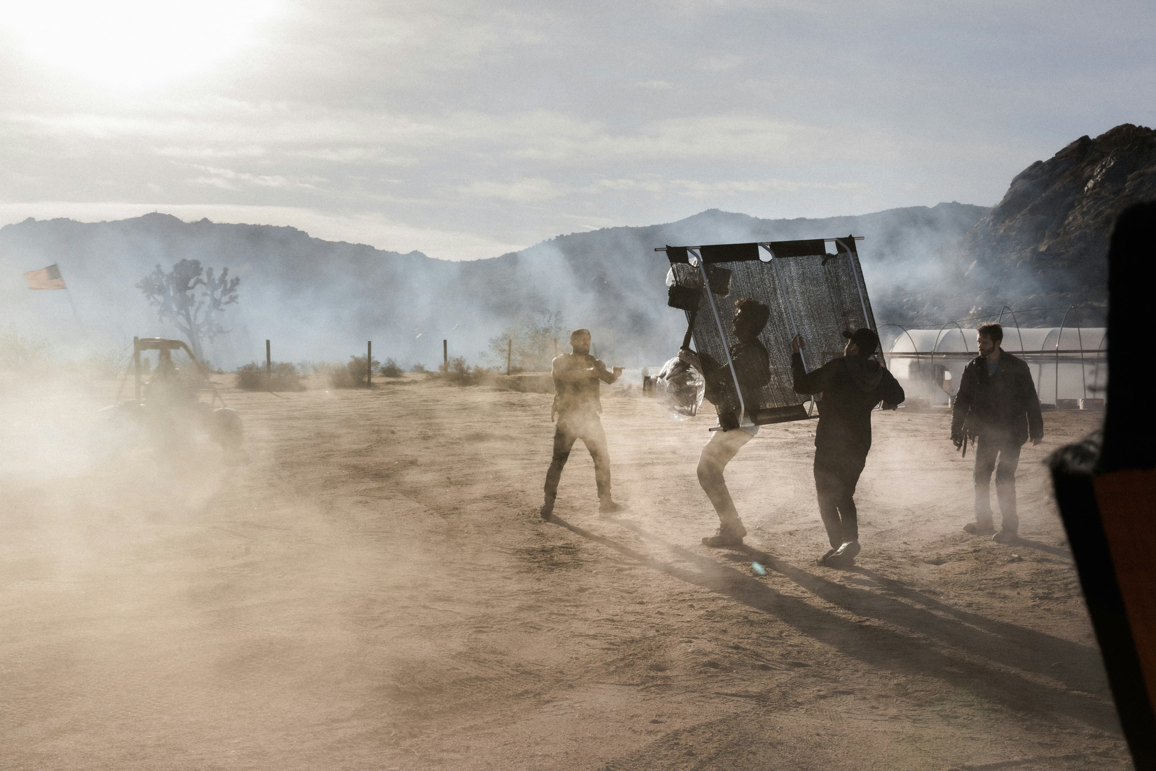 Film crew working on set in dusty desert conditions